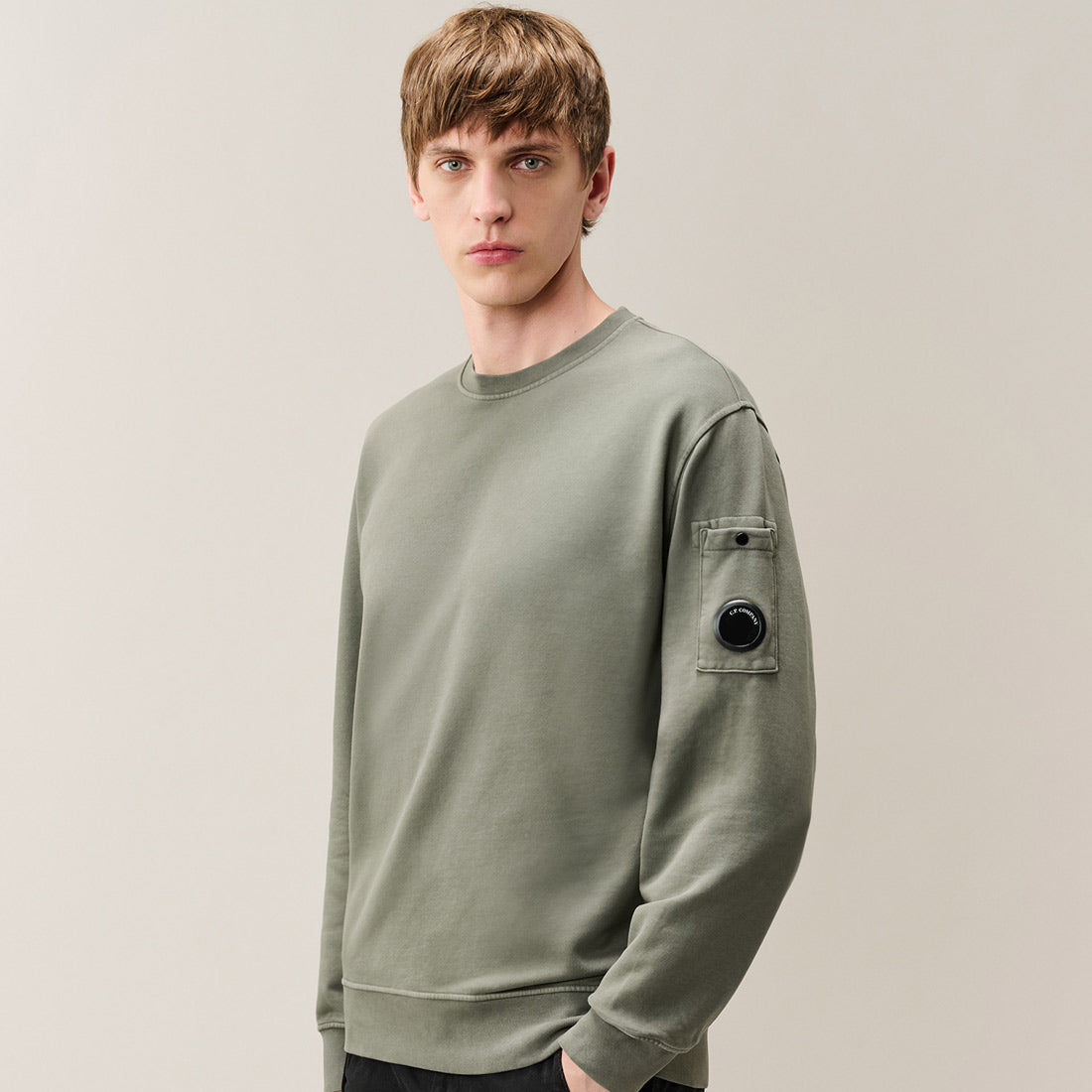 Man wearing CP Company Brushed and Emerized Diagonal Fleece Lens Crewneck Sweatshirt Castor Grey