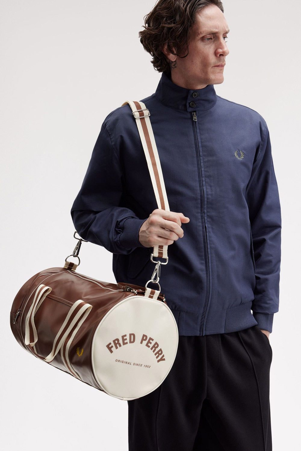 a man wearing a fred perry Classic Barrel Bag Tan Ecru over his shoulder