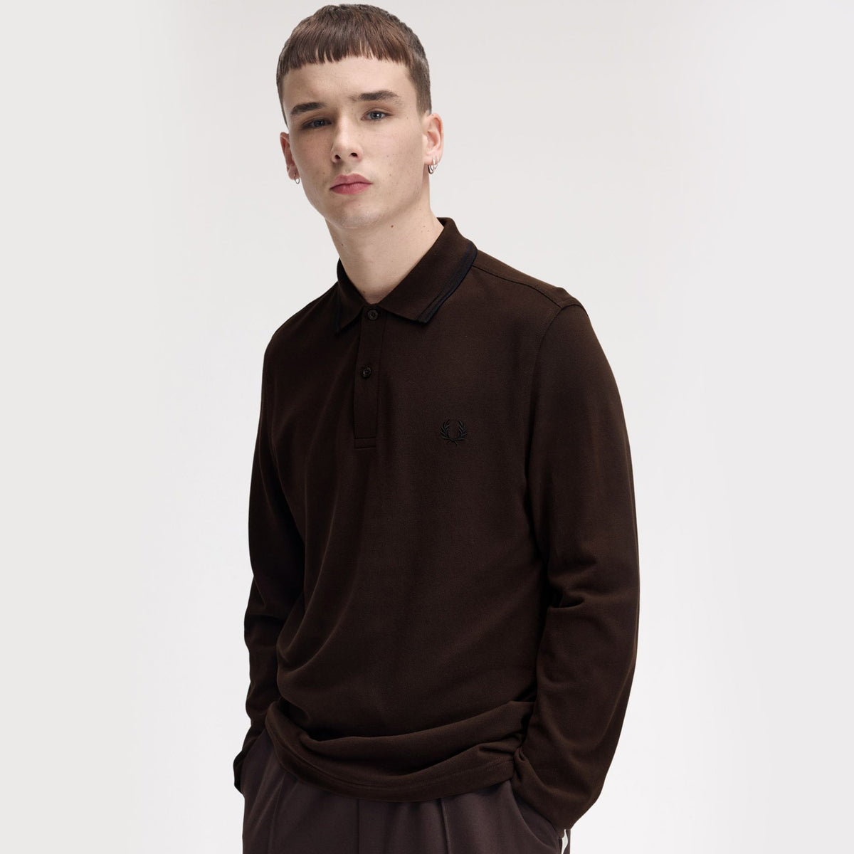 A man wearing fred perry Long Sleeve Twin Tipped Polo Shirt Rich Brown / Black