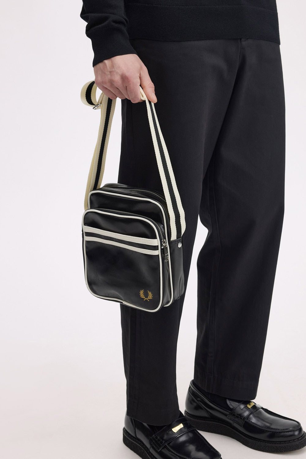 man carrying fred perry Classic Side Bag Black in his hand
