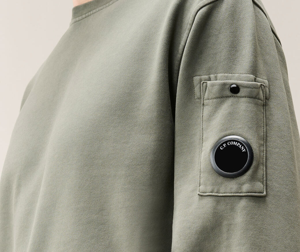 Close up of lens badge on C.P. Company sweatshirt