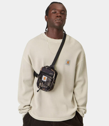Man wearing a Carhartt WIP Kickflip Shoulder Bag Camo Feather Tree