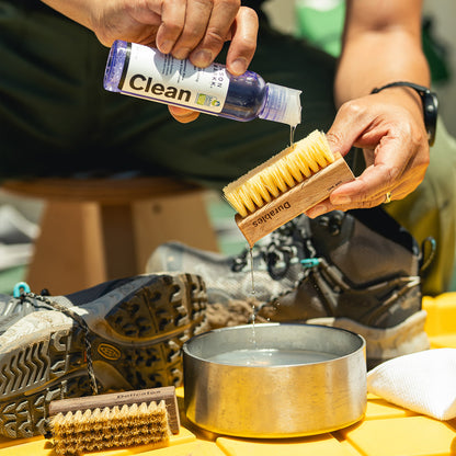 man cleaning his sneakers with jason markk cleaning fluid and brush from essential cleaning kit