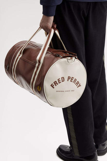 man holding a fred perry Classic Barrel Bag Tan Ecru in his hand