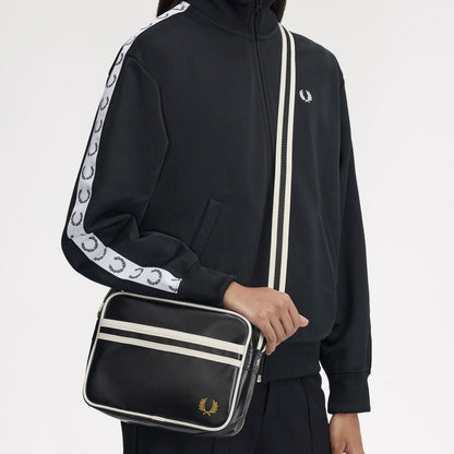 Person wearing a fred perry shoulder bag in black