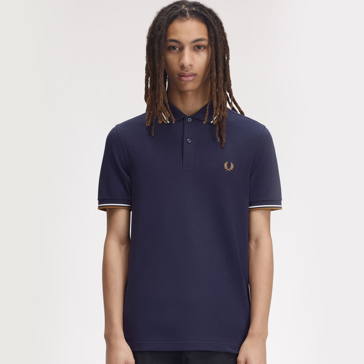 A man wearing fred perry Short Sleeve Twin Tipped Polo Shirt Twilight Navy / Snow White / Dark Caramel
