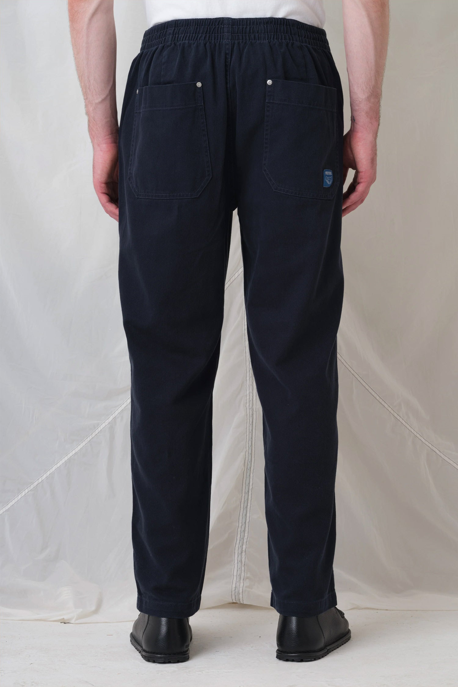 a person shown from the back wearing pexwear c trousers - chef trousers - in navy