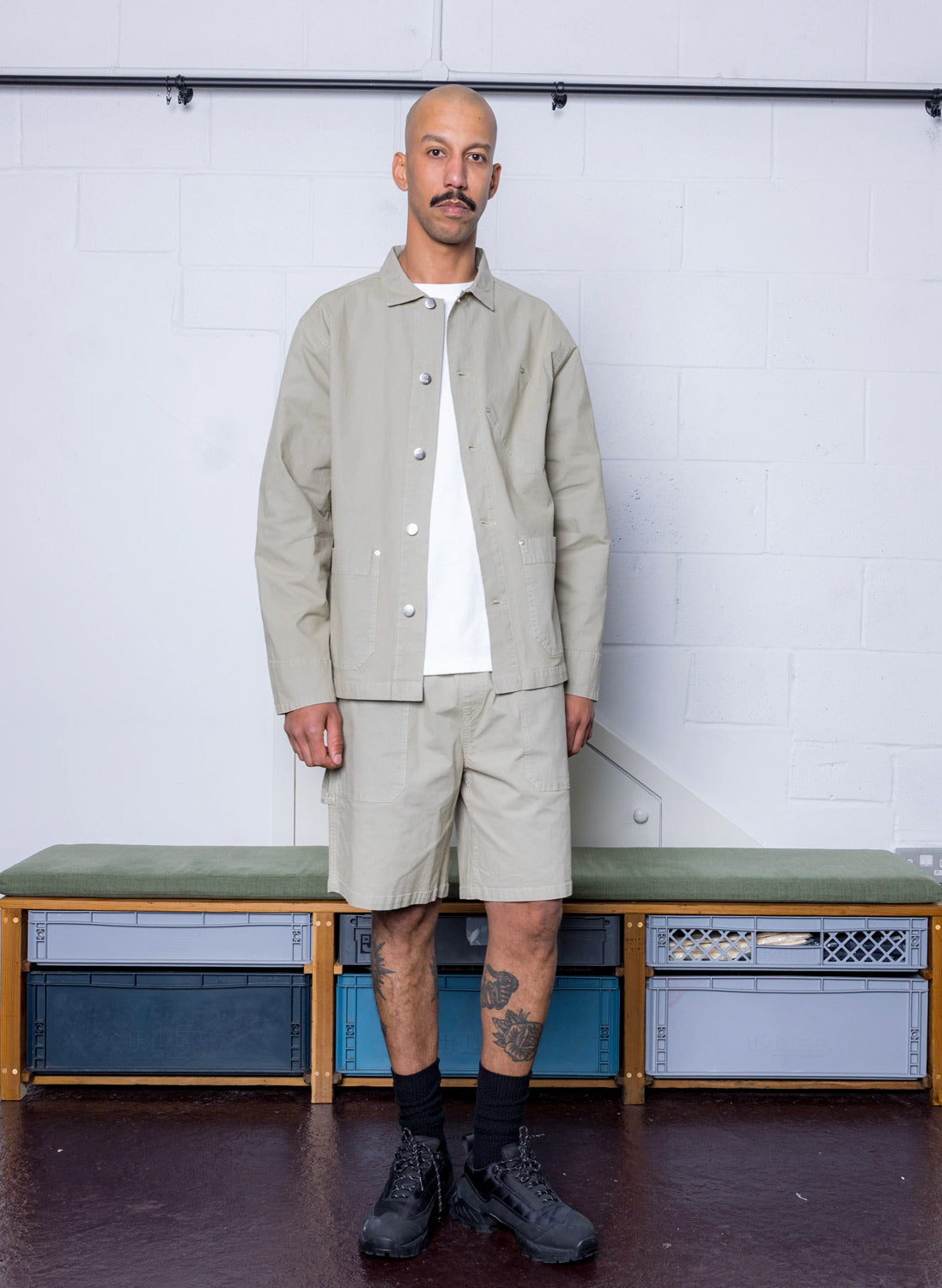 A man wearing Pexwear Ripstop jacket and shorts in faun green