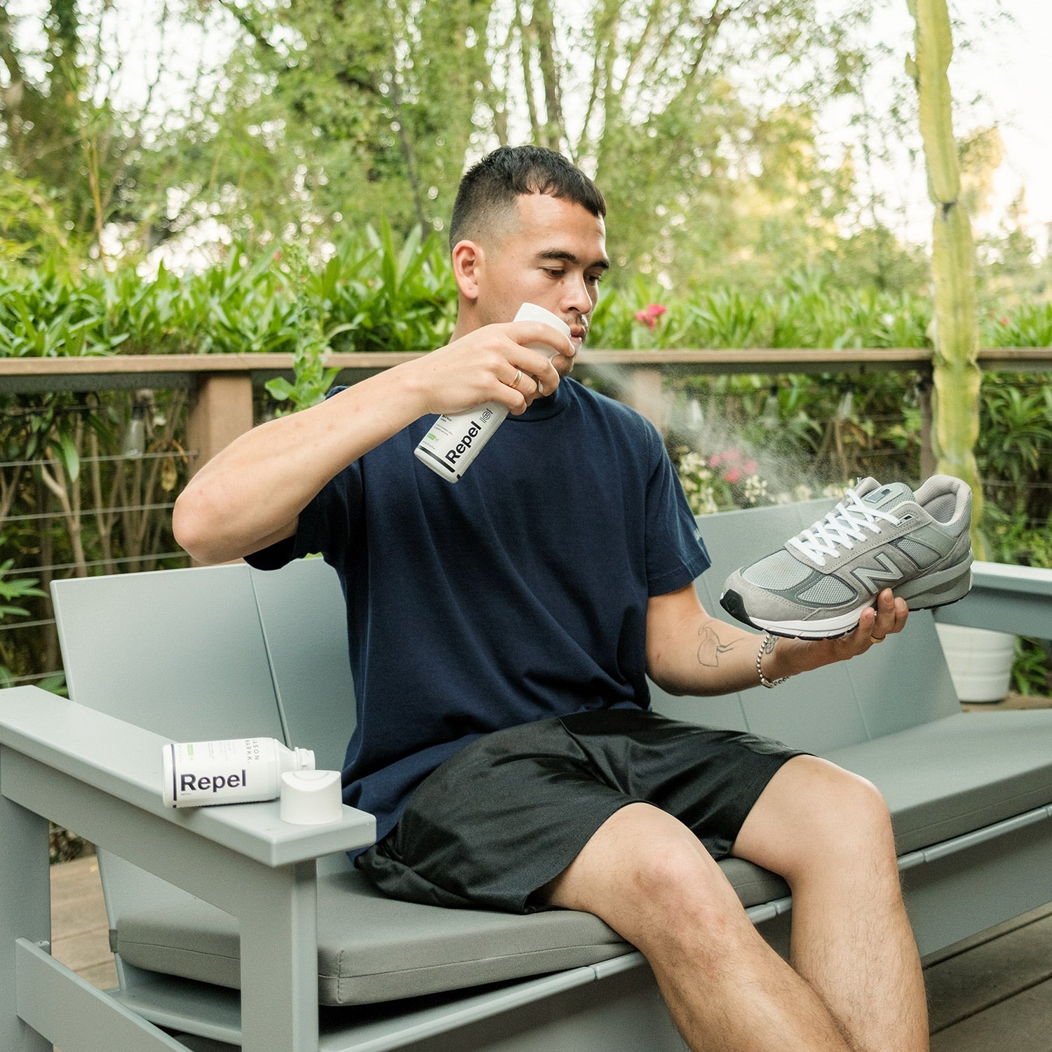 man spraying his trainers with jason markk repel spray to protect them